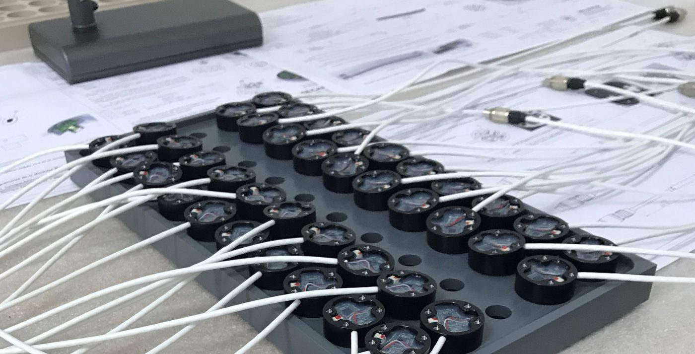 Réseau de capteurs acoustiques câblés sur leur plaque support, avec la documentation technique associée